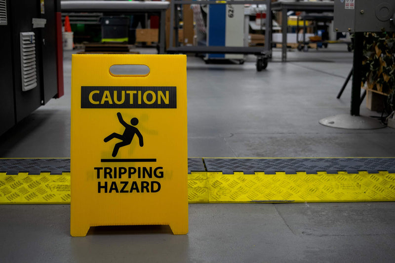 NMC FS36 CAUTION TRIPPING HAZARD Sign with Graphic - 12 in. x 19 in. Corrugated Plastic, Double-Sided Floor Sign with Black on Yellow